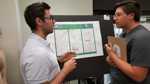 Brian Freeman judging poster presentations during their practice session, Summer 2017